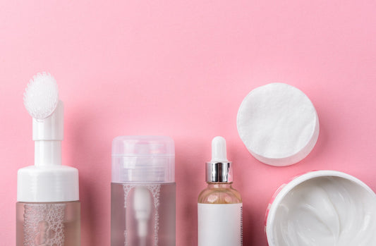 layout of different skincare products against a pink background