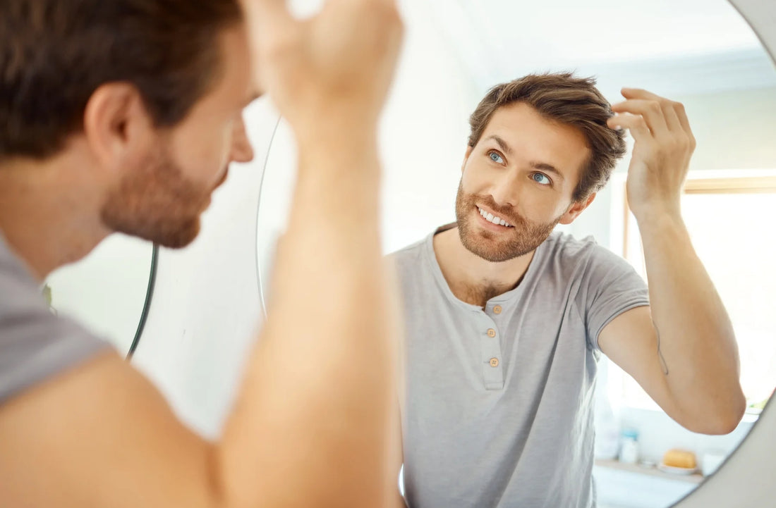 man looking at his hair growth in the mirror